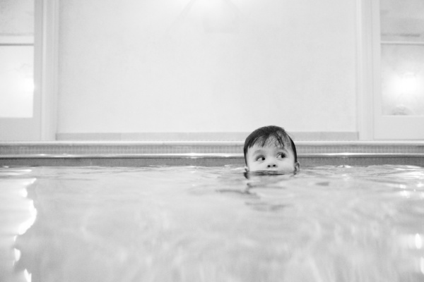 A child peers above the surface of a pool.