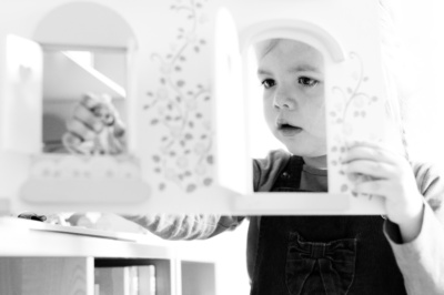 A child plays with a dolls house.