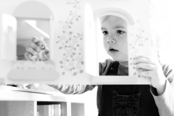 A child plays with a dolls house.