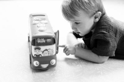 A child plays with a toy bus.