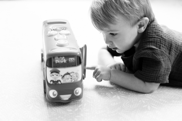 A child plays with a toy bus.