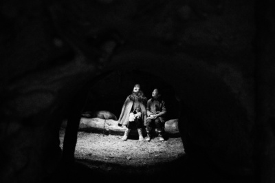 Children sit together in a patch of light.