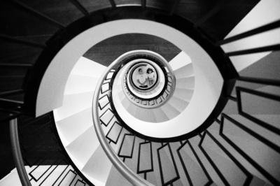 Children lie at the bottom of circular stairs.