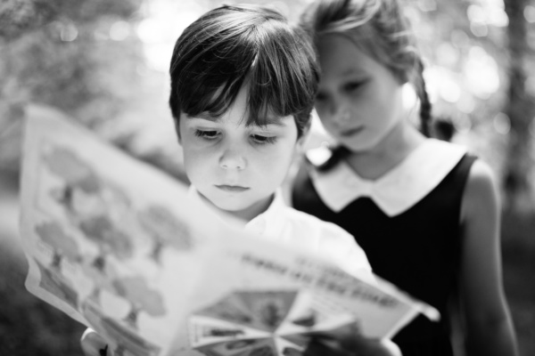 Children look at a book together.