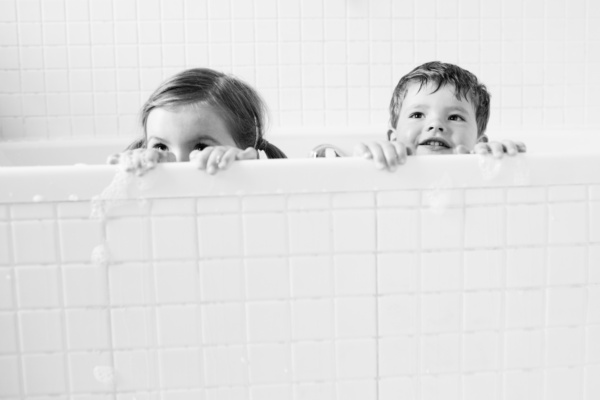 Children look out of a bubble bath.