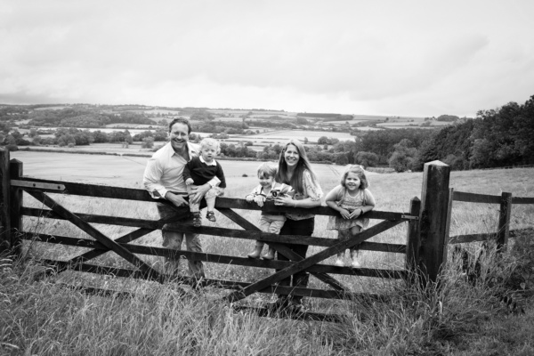 Children and their parents pose portraits on gate.