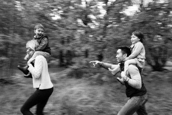 Parents carry their children through a park.