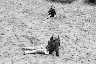 Brother and sister play in the sand.