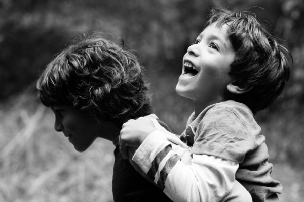 Two boys play in the grass.