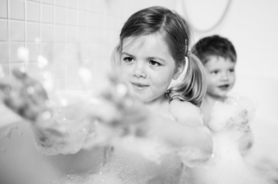 Children play with bubbles in bath.