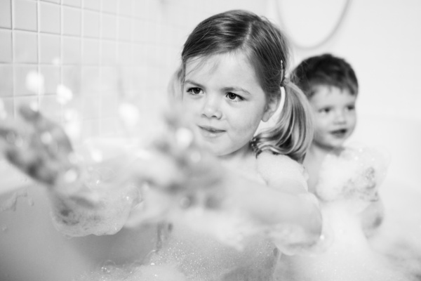 Children play with bubbles in bath.