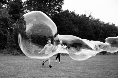 Children play with a giant balloon in a field.