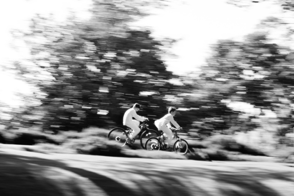 Children ride their bikes through gardens.