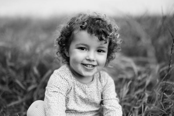 Child's portrait on the grass in black and white.