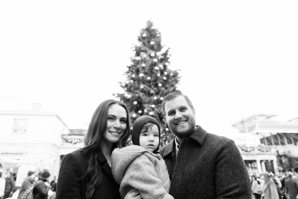 Christmas portrait of parents and their child in Covent Garden in front of a Christmas tree.