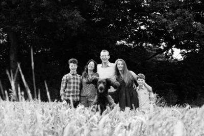 Family and spaniel portrait in a field.