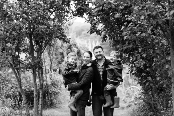 A family portrait framed by curling tree branches.