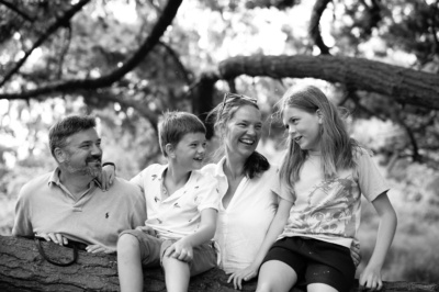 A family portrait posed on a log.