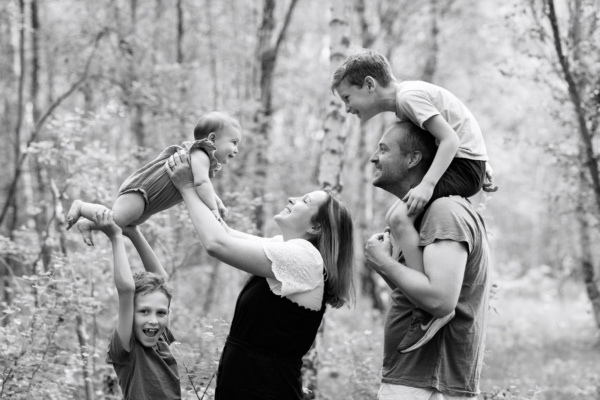 A family portrait with a baby in the woods.