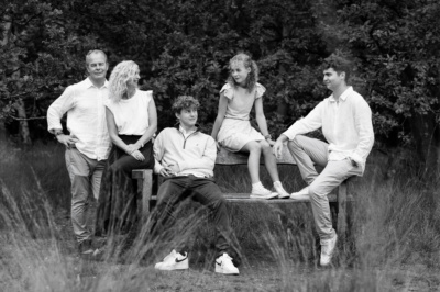 A family portrait with teenagers on a garden bench.