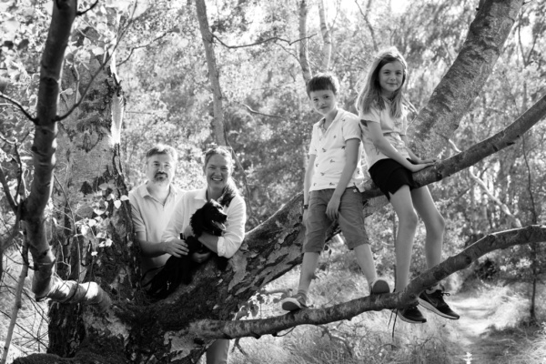 A family portrait with their dog in a tree.