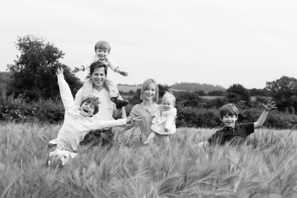 Family portraits with parents and children in a field.