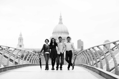 A family of four on London's Millennium Bridge for a black and white portrait, with St Paul's Cathedral in the background.