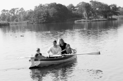 A family of four rows across the water.