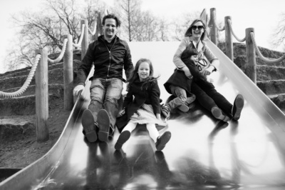 A family slides down a slipper slide together.