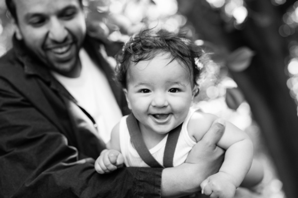 Father holds baby in a woodland.