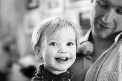 Father holds daughter in his lap.