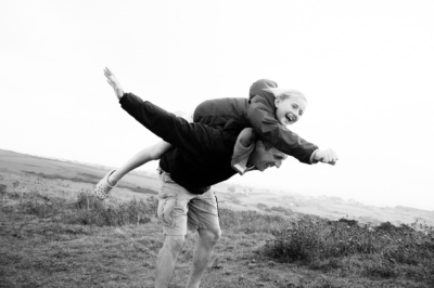 Father piggybacks daughter across field.