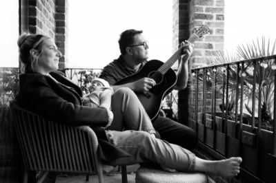 Father plays guitar to his newborn baby.