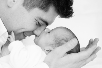 A father snuggles his newborn baby.