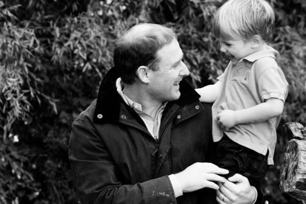 Father and son giggle together outdoors.