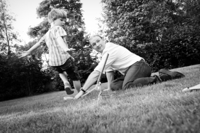 Father and son play in a garden.