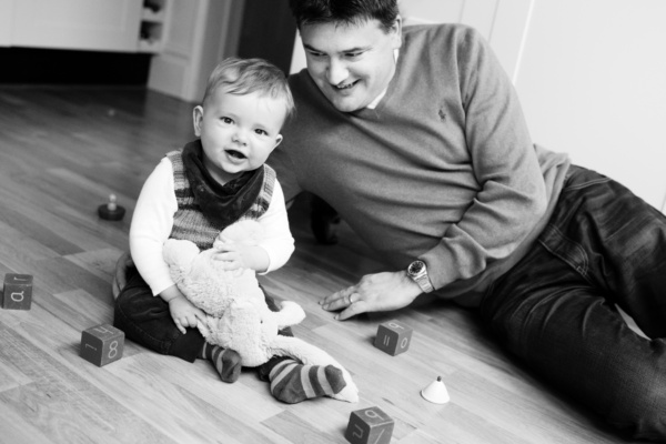 A father and won play with blocks on the floor.