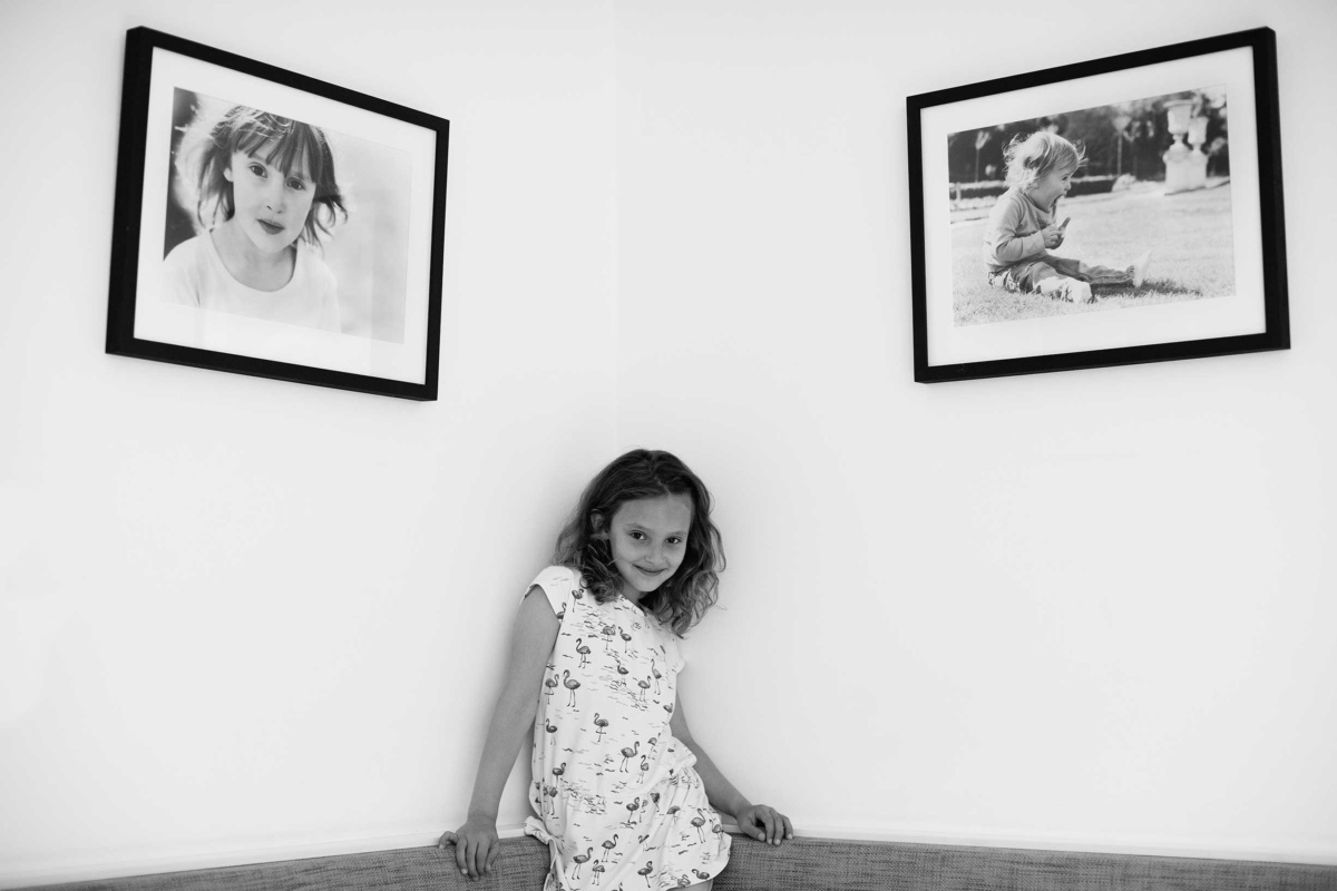 Fine art framed family portraits with white mounts and black frames.