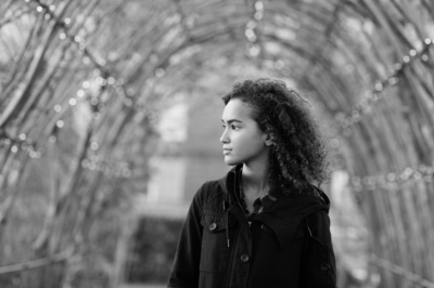 A garden arch frames a teenage portrait in monochrome.