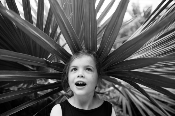 A giant leaf frames the face of a girl.