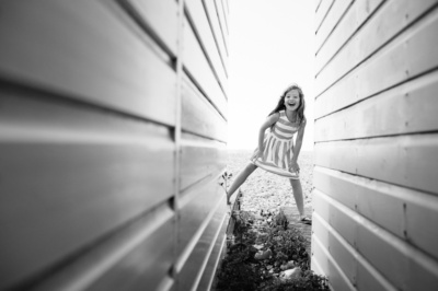 A girl runs between beach houses.