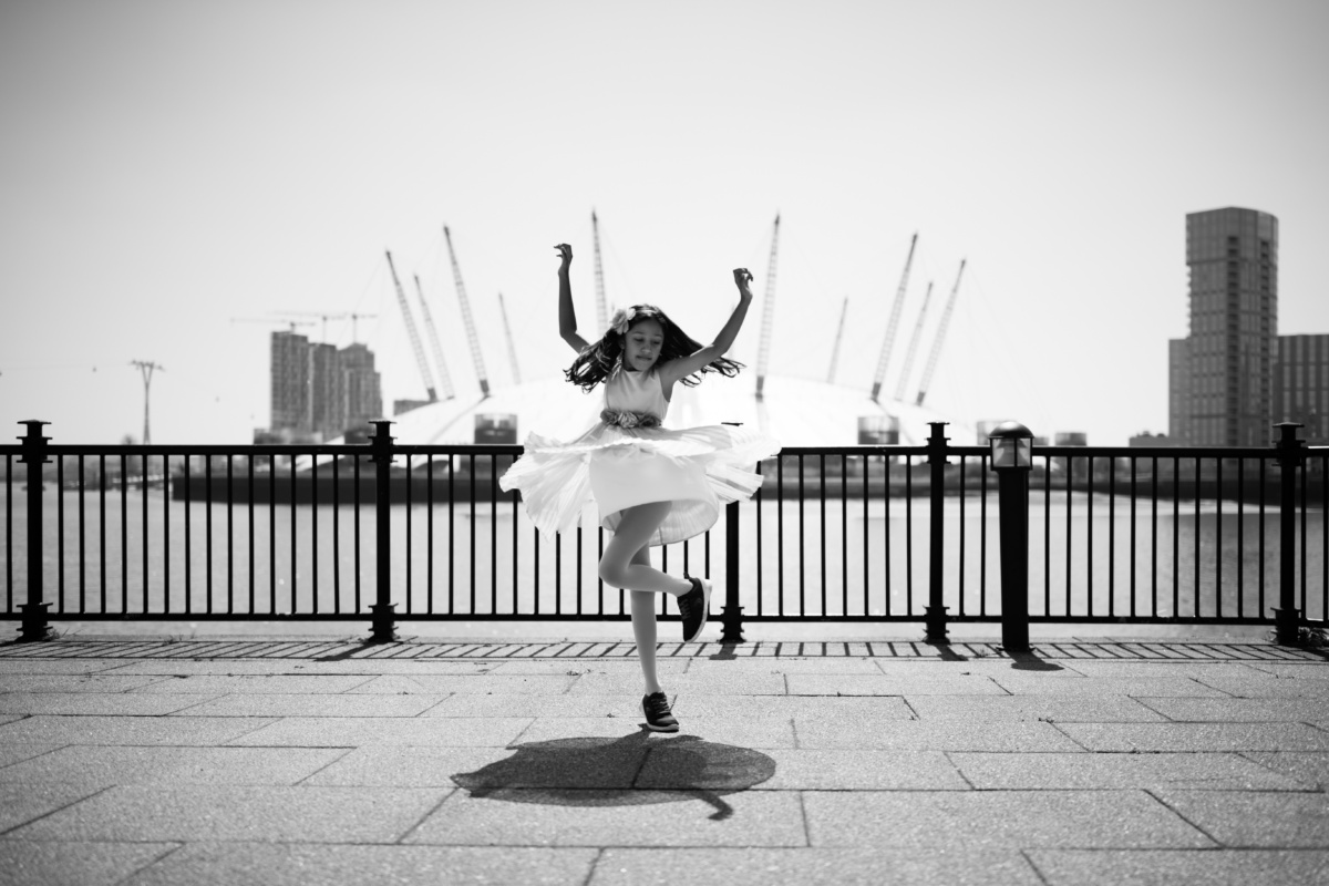 A girl dances with Greenwich in the background.