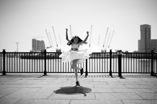 A girl dances with Greenwich in the background.