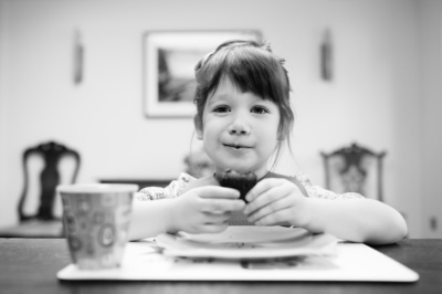 A girl eats chocolate cake.