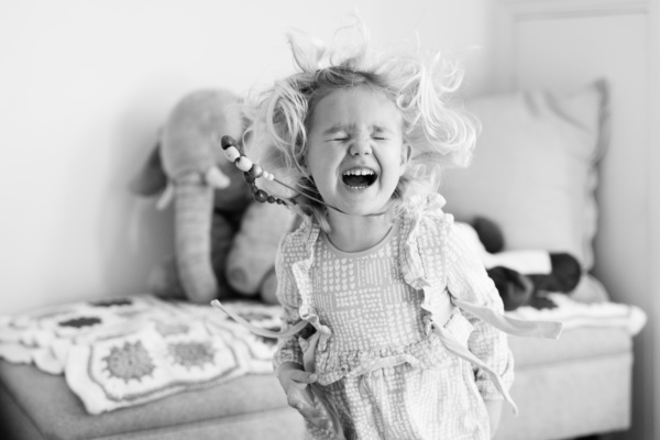 A girl giggles in a family photo shoot.