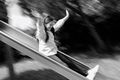 Girl does down slide at speed.