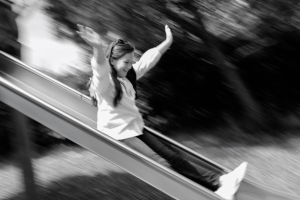 Girl does down slide at speed.