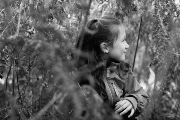 A girl hides in ferns.