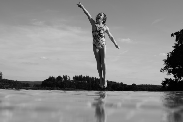 A girl jumps into water.