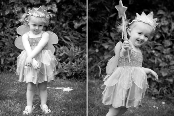 A girl plays in a garden, wearing a fairy outfit.